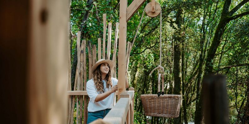 A woman with a hat collects the breakfast basket from her lodge