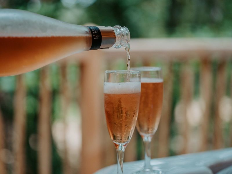 Deux verres se faisant remplir sur la terrasse d'un lodge de Calviac